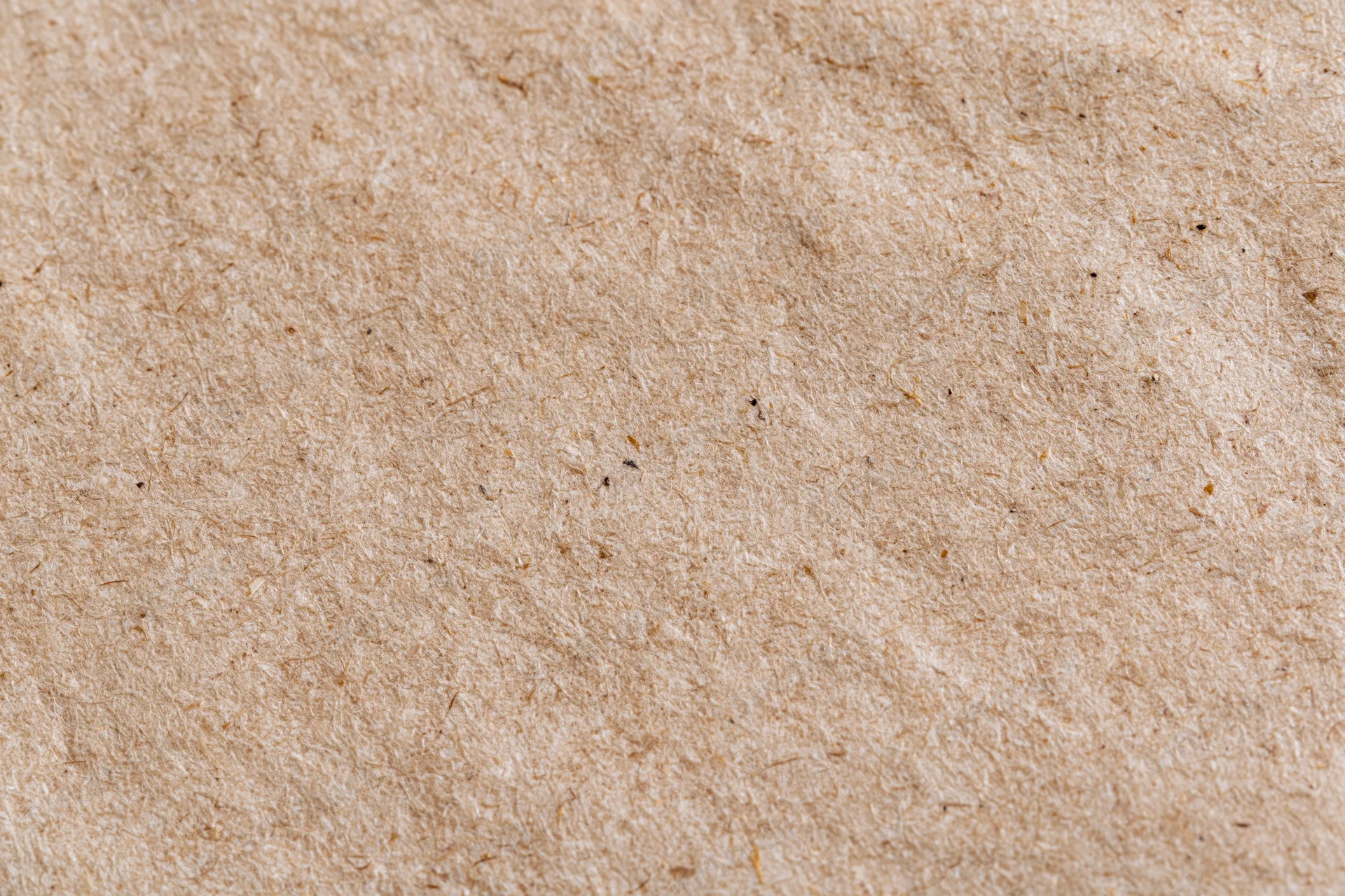 Close-up flat lay of a sheet of recycled kraft paper filling the frame