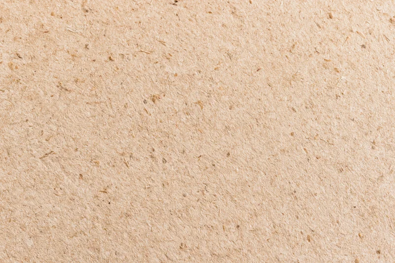 Close-up flat lay of recycled kraft cardboard surface filling the frame
