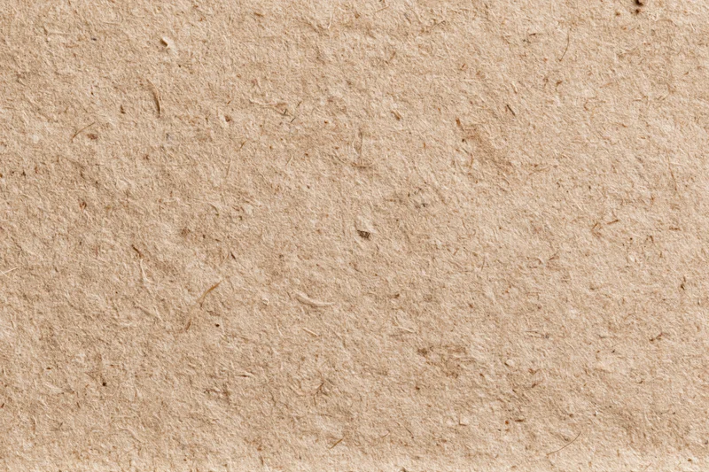 Close-up flat lay of recycled kraft cardboard surface filling the frame
