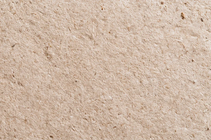Close-up flat lay of recycled kraft cardboard surface filling the frame