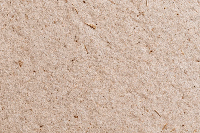 Close-up flat lay of recycled kraft cardboard surface filling the frame