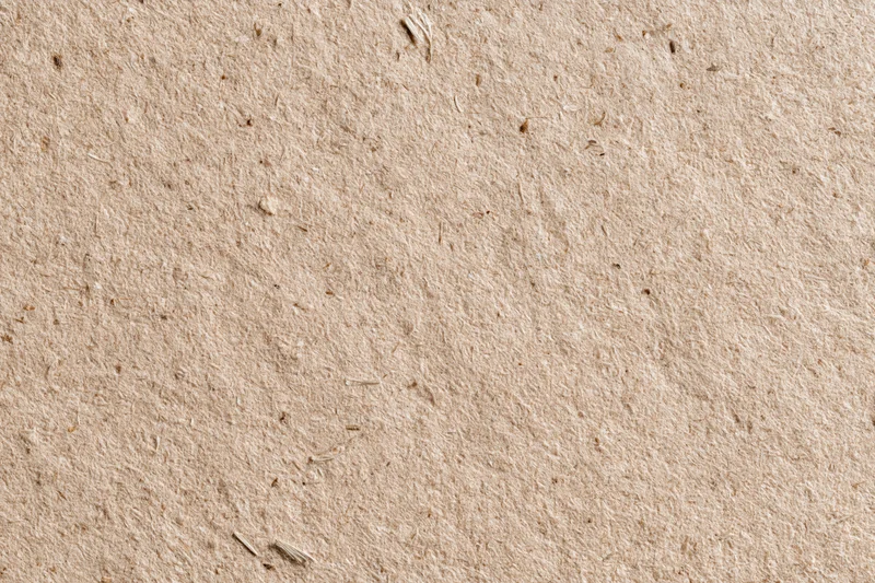 Close-up flat lay of recycled kraft cardboard surface filling the frame