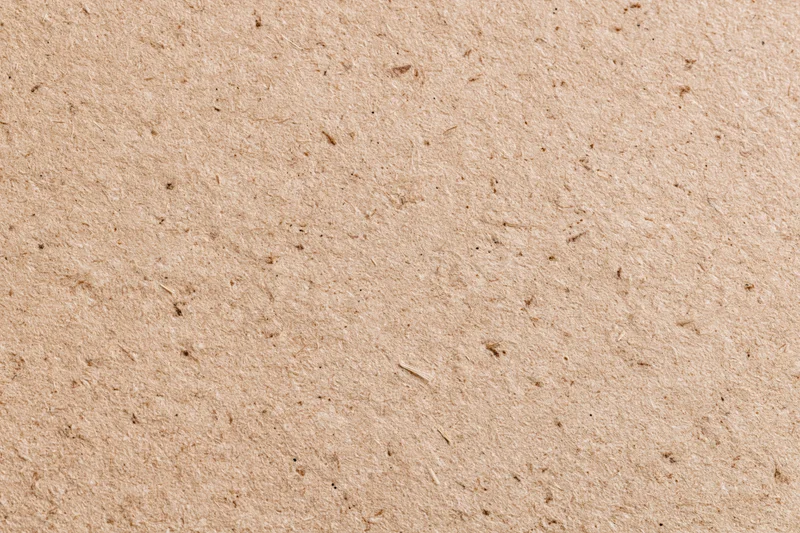 Close-up flat lay of recycled kraft cardboard surface filling the frame
