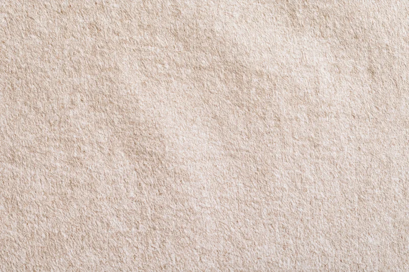 Close-up flat lay of beige recycled kraft paper with linen-like texture as background