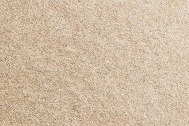 Close-up flat lay of recycled kraft paper with natural fiber texture and beige tone