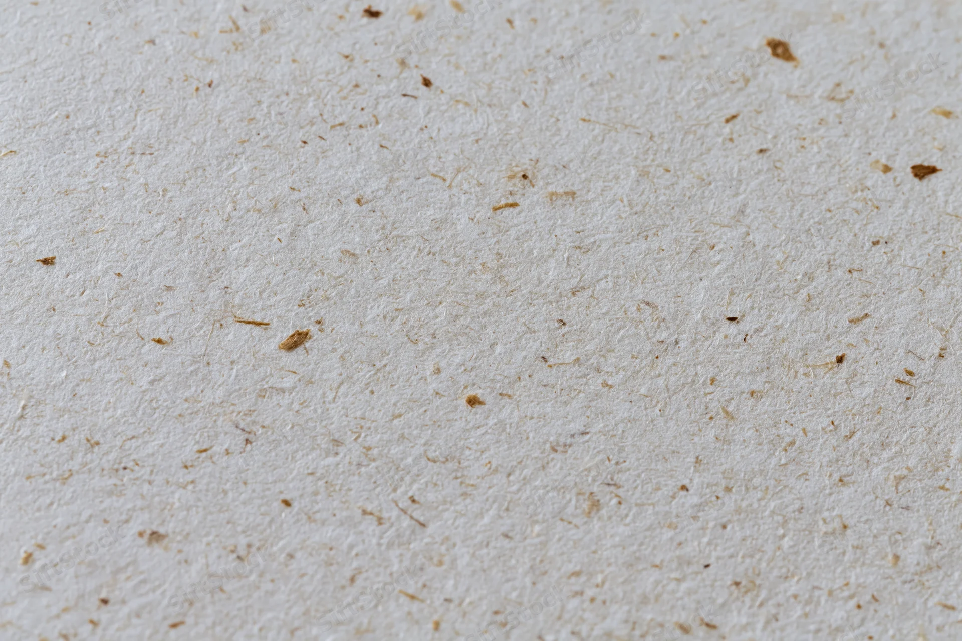 Close-up flat lay of recycled kraft paper surface filling the frame with visible fibers and speckles