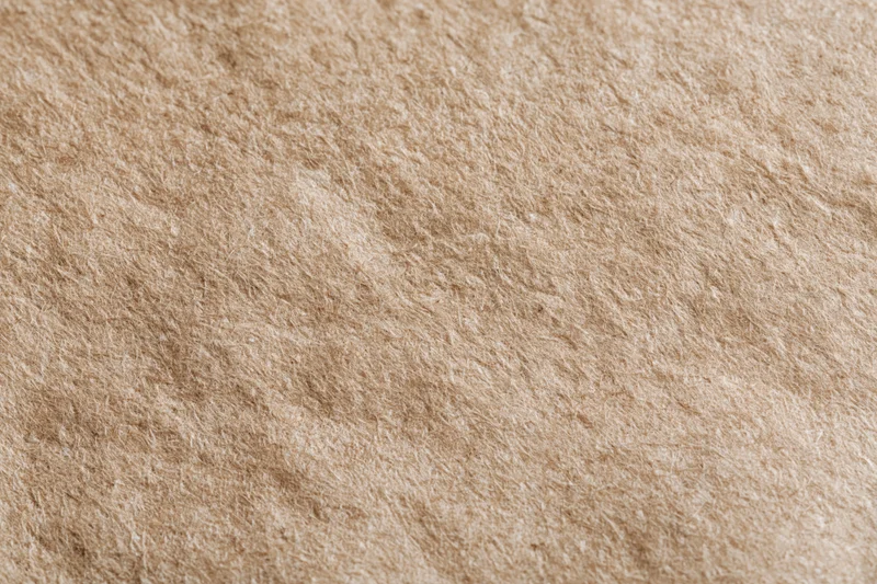 Close-up flat lay of recycled kraft paper surface filling the frame