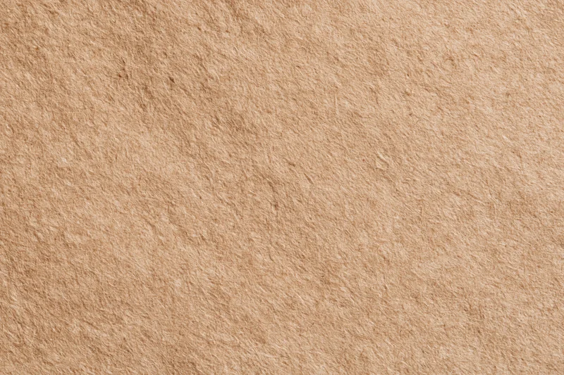 Close-up flat lay of recycled kraft paper surface filling the frame
