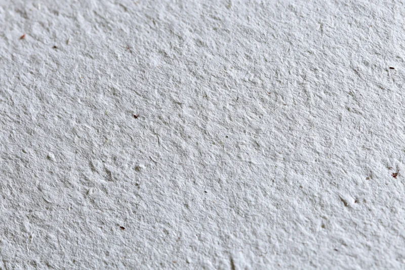 Close-up flat lay of recycled white paper surface filling the frame