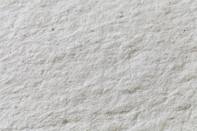 Close-up flat lay of recycled white paper surface filling frame