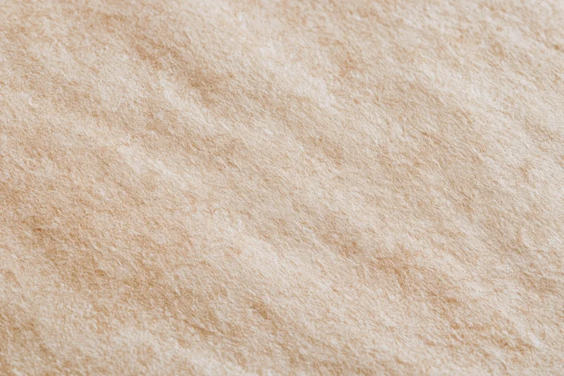 Close-up flat lay of unbleached kraft paper surface filling frame