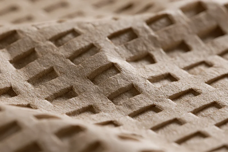 Close-up of embossed kraft paper surface with grid pattern