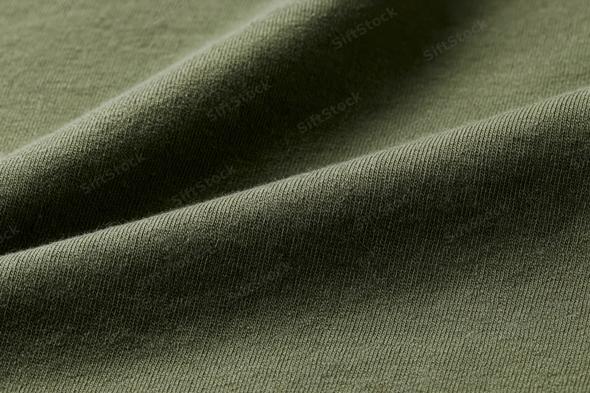 Close-up of dark olive green cotton jersey fabric with visible knit texture and folds
