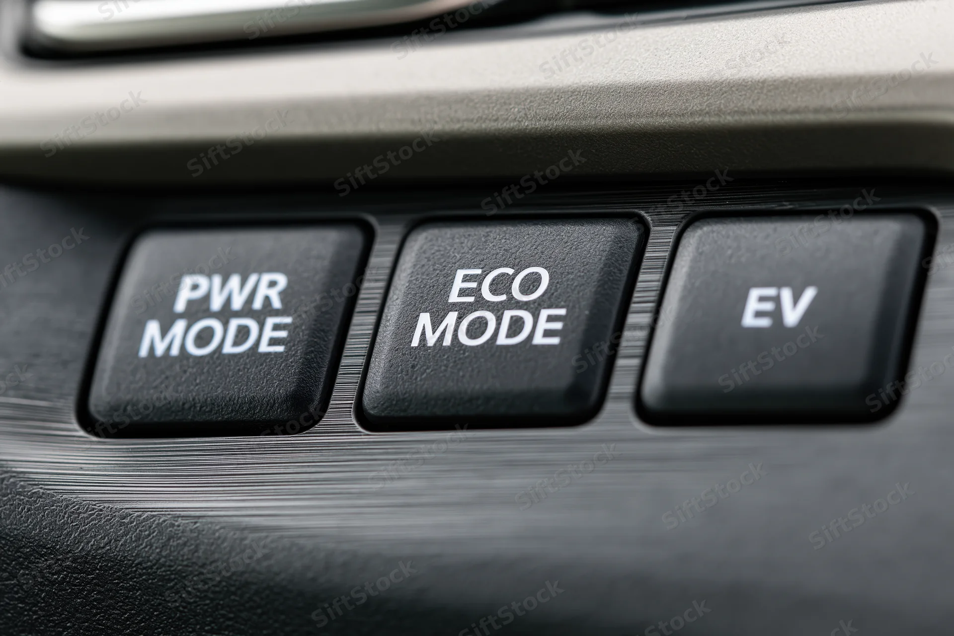 Close-up of car dashboard control panel with power, eco, and ev mode buttons arranged horizontally