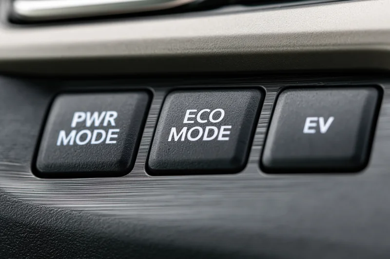 Close-up of car dashboard control panel with power, eco, and ev mode buttons arranged horizontally