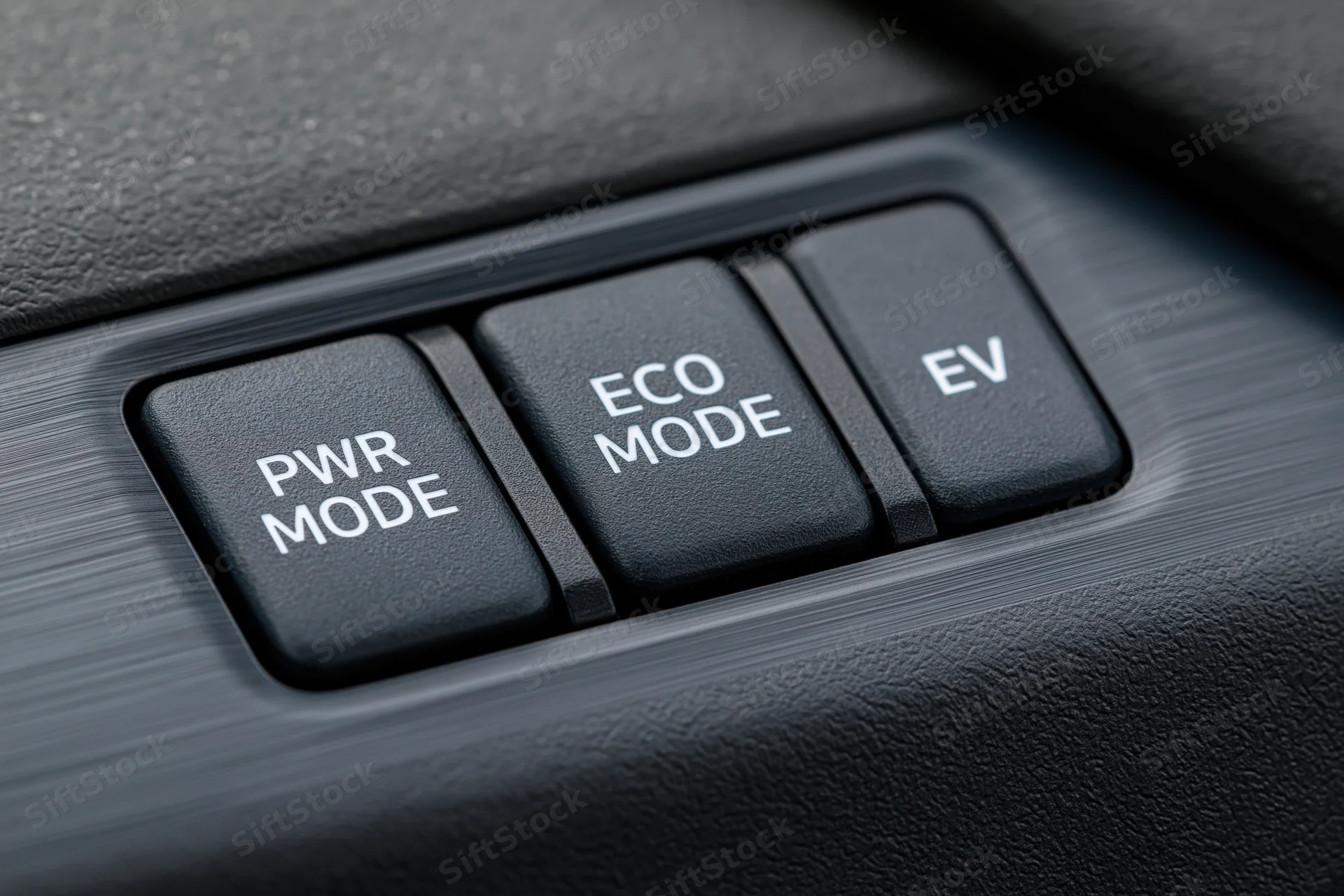 Close-up of car dashboard control panel with power mode, eco mode, and ev buttons arranged in a row