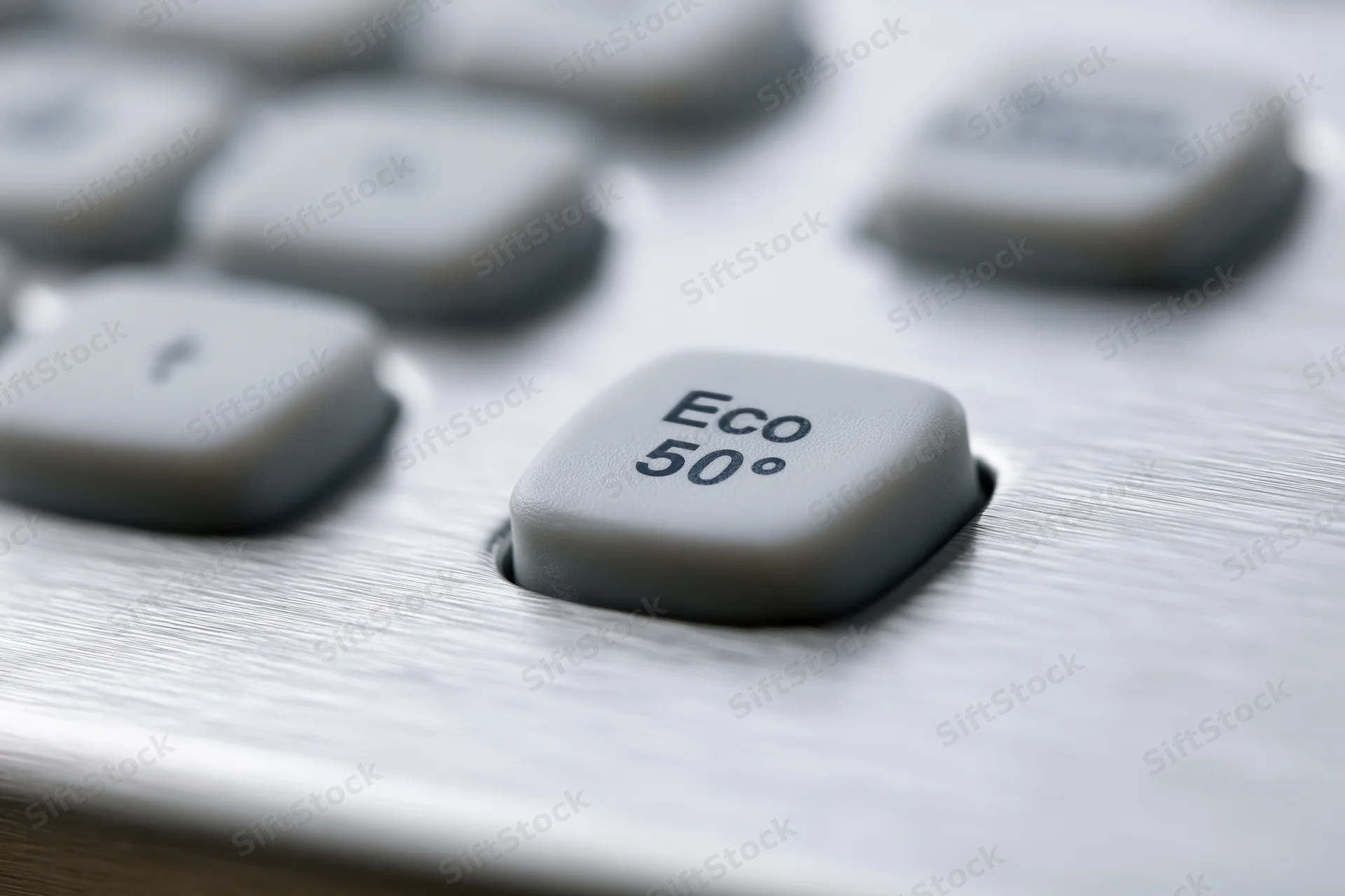 Close-up of dishwasher control panel buttons on brushed stainless steel surface with eco 50 degree setting in focus