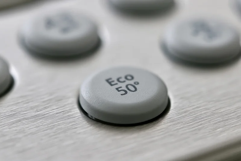 Close-up of dishwasher control panel buttons with eco 50 degree setting on brushed stainless steel surface