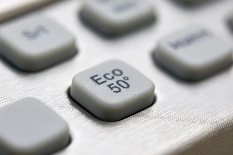 Close-up of dishwasher control panel buttons with eco 50 degree setting on brushed stainless steel surface