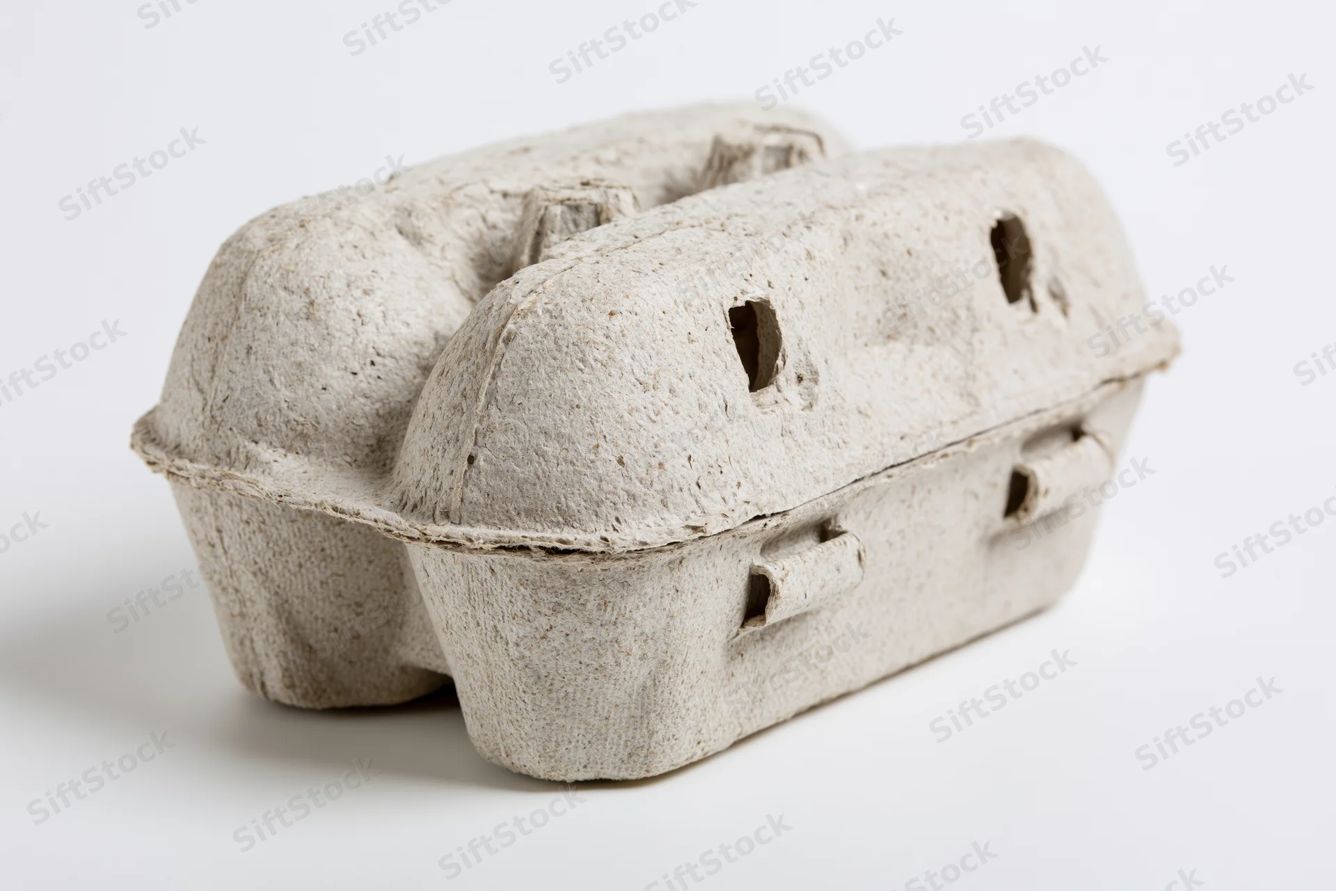 Closed cardboard egg carton resting on a plain white surface