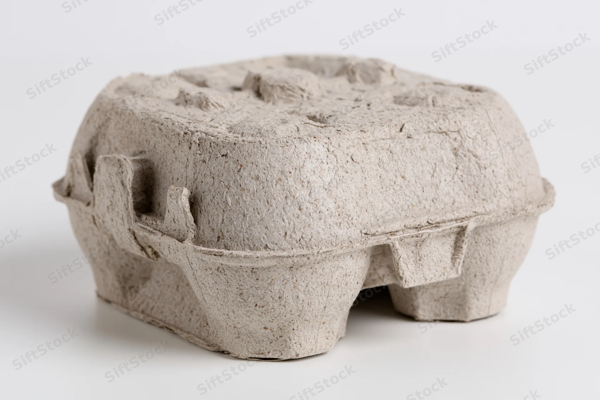 Closed cardboard egg carton on plain white surface