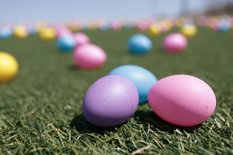 Colorful plastic easter eggs scattered across a green grassy lawn