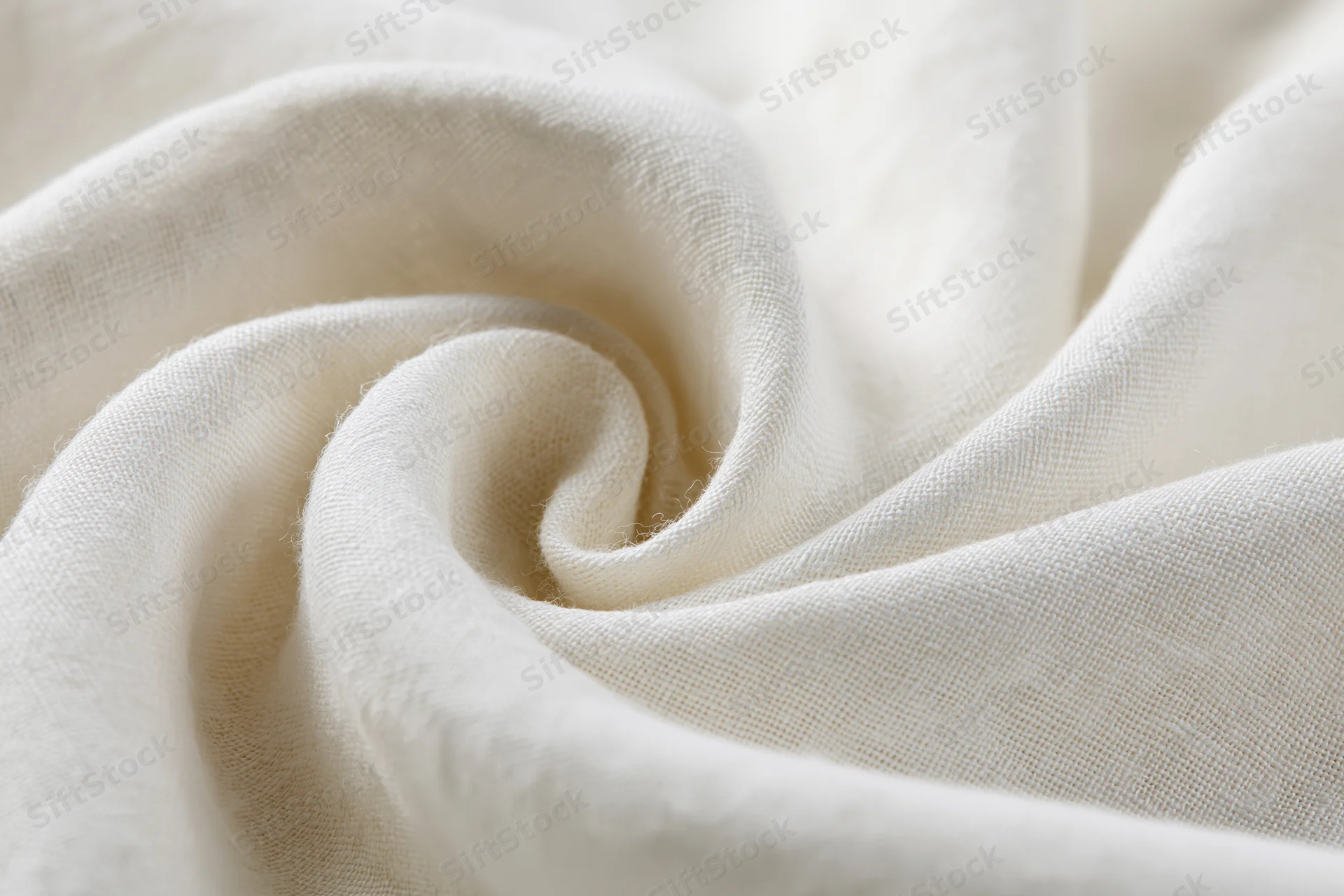 Cream-white linen fabric draped in soft flowing folds forming a swirl