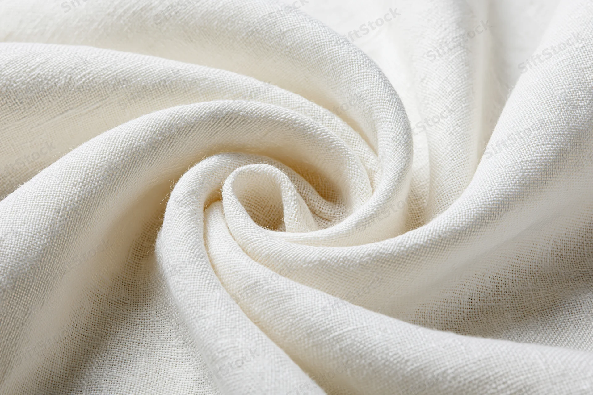 Cream-white linen fabric draped in soft flowing folds forming a swirl pattern