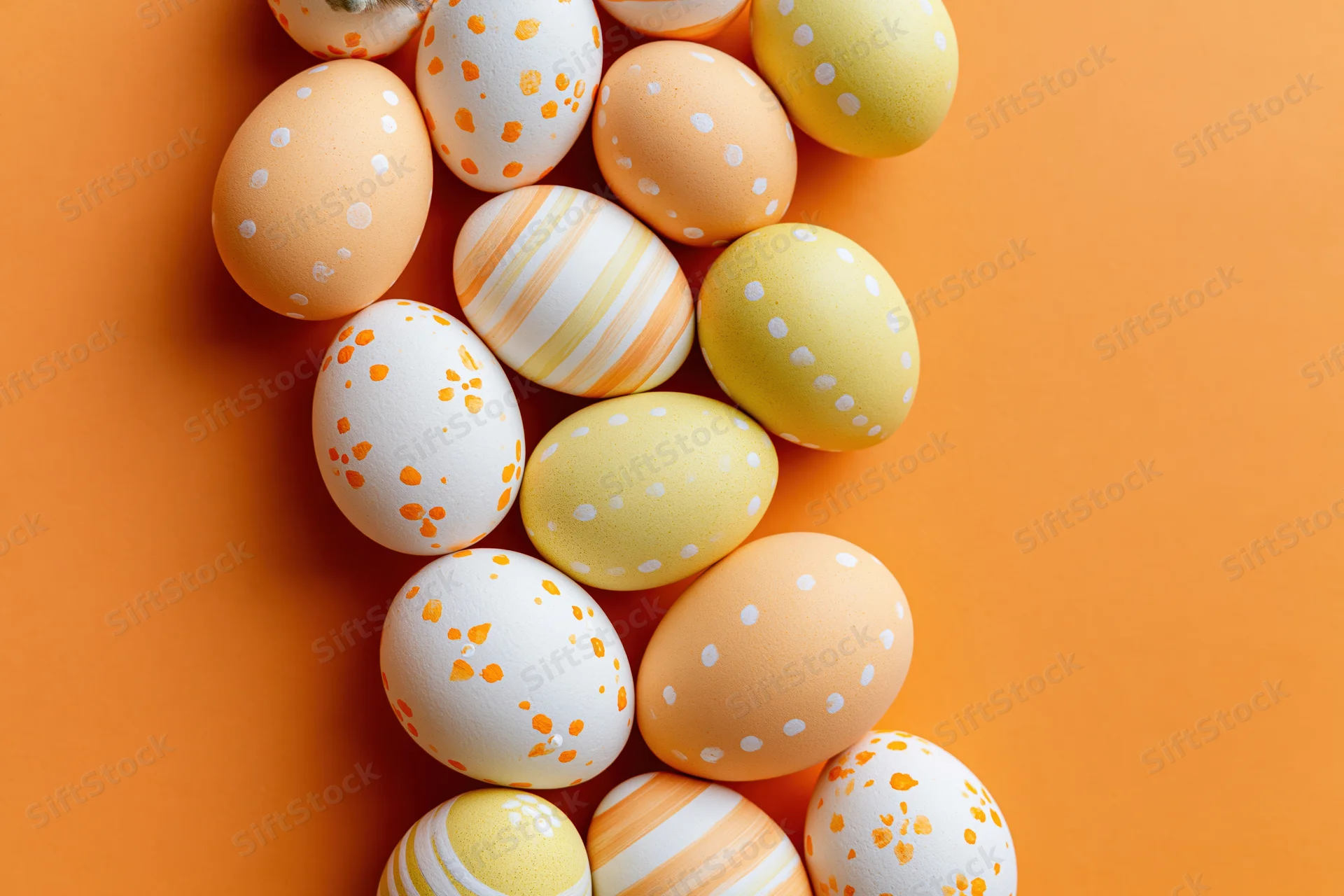 Decorated easter eggs arranged in a loose vertical cluster on orange background with copyspace
