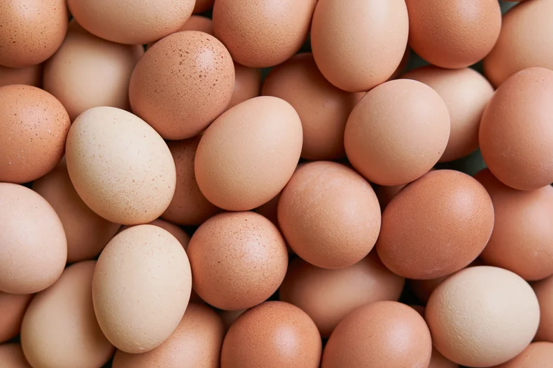 Brown chicken eggs piled loosely filling the frame