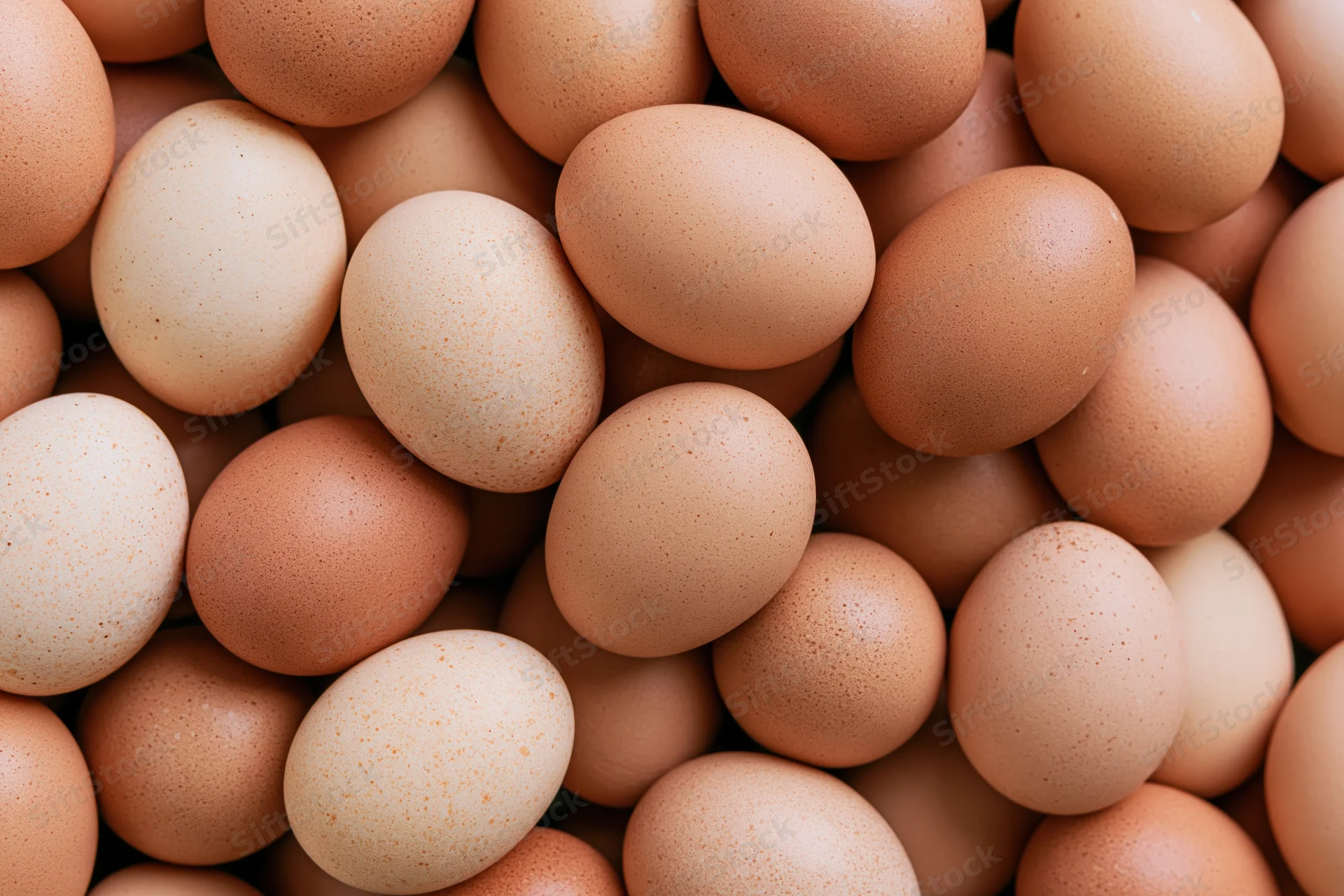 Brown chicken eggs piled loosely filling the frame