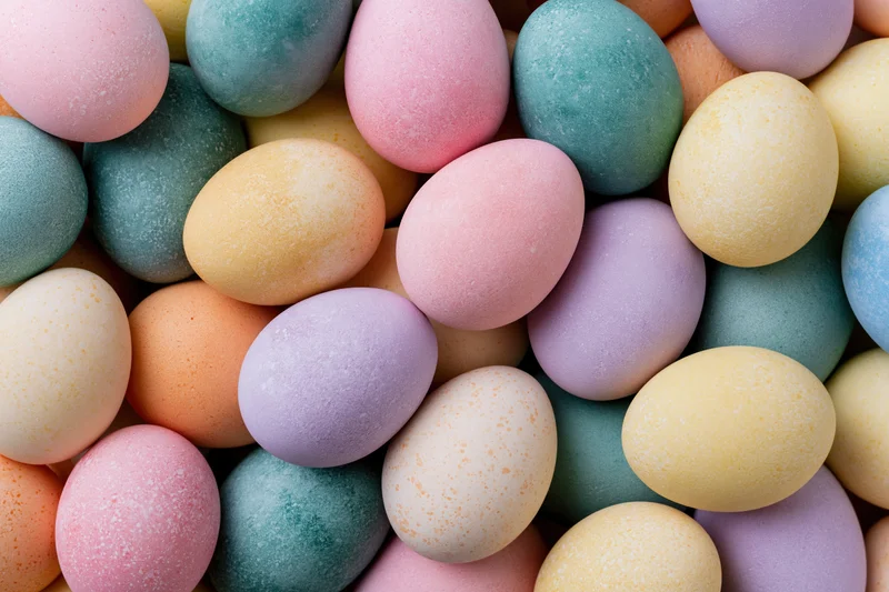 Dyed easter eggs arranged in a flat pile filling the frame