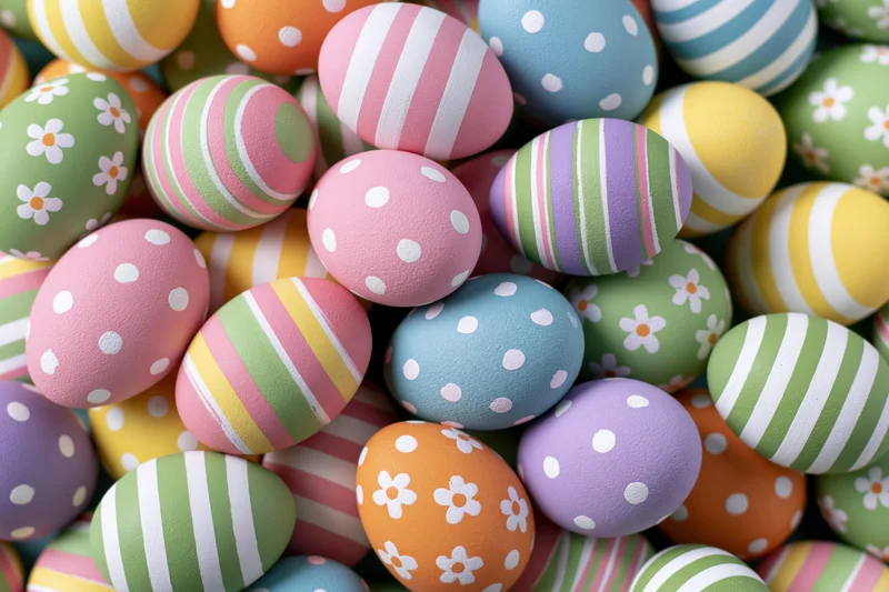 Hand-painted easter eggs piled together in a colorful arrangement filling the frame