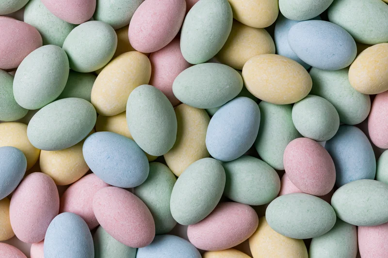 Pastel candy-coated chocolate eggs filling the frame in a close-up still life arrangement