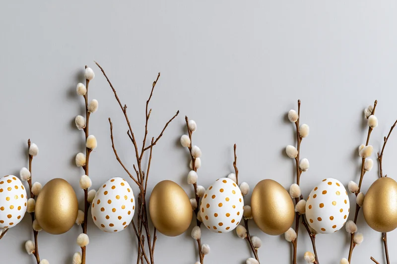 Easter eggs and pussy willow branches arranged in a flat lay on a gray surface