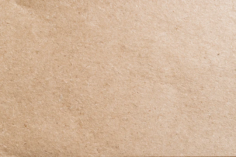 Flat lay close-up of a plain kraft brown paper sheet filling the frame