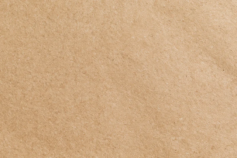 Flat close-up of a plain kraft brown paper sheet filling the frame