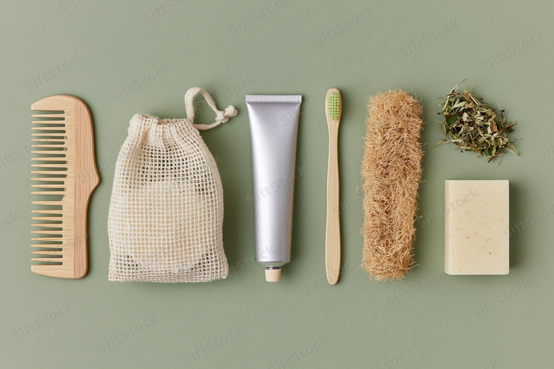 Zero-waste bathroom essentials arranged in a flat lay on a green background