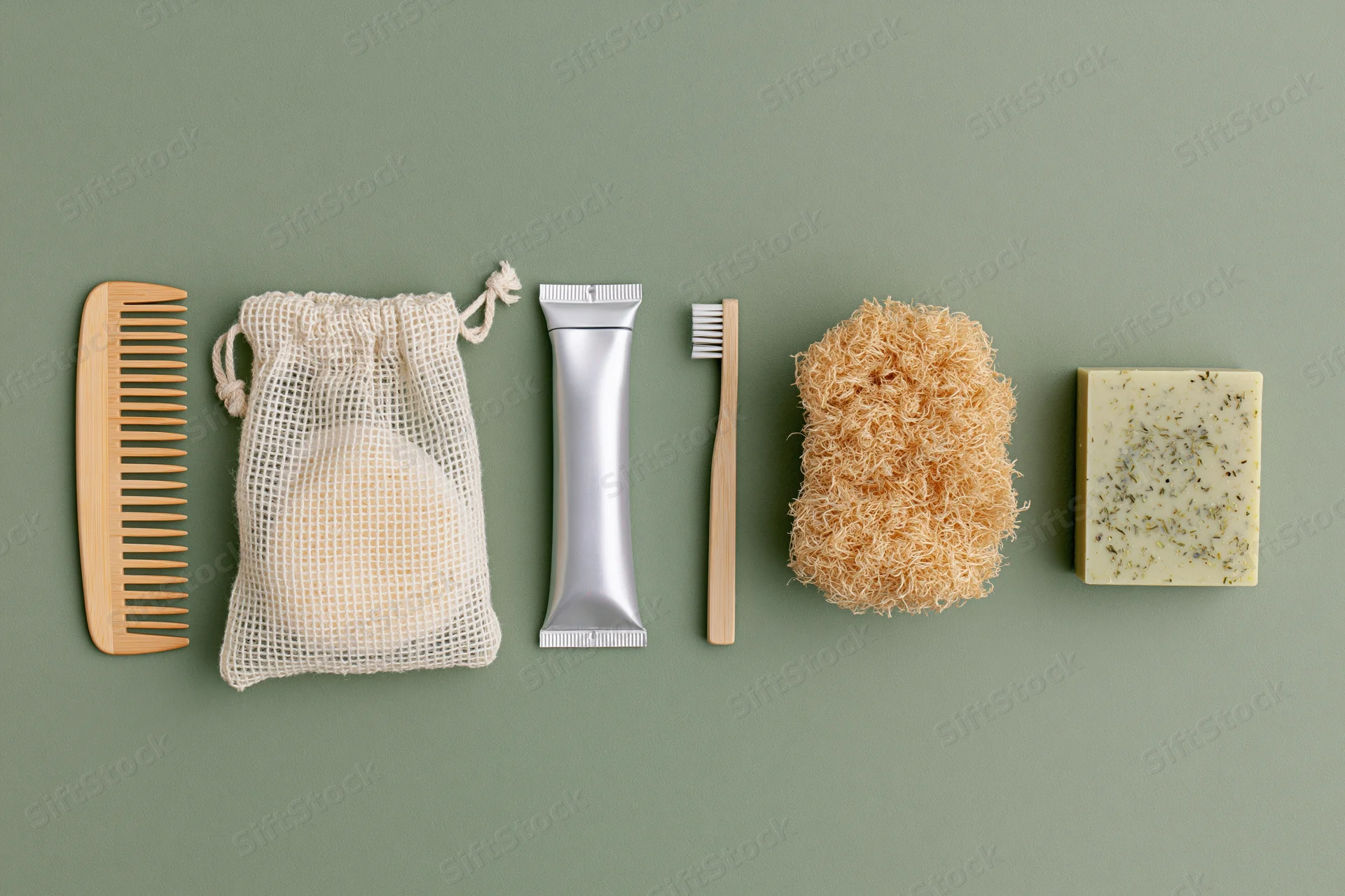 Zero-waste bathroom essentials arranged in a neat flat lay on green background
