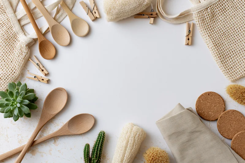 Zero-waste household items arranged as a border on a white surface with copyspace