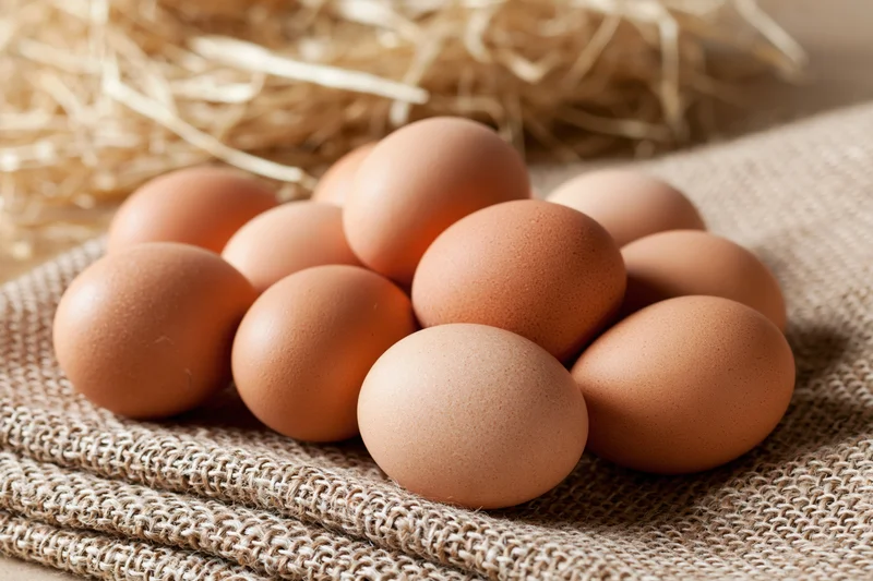 Brown chicken eggs scattered on folded burlap cloth