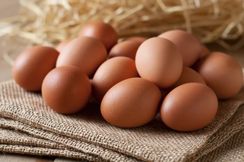 Brown chicken eggs scattered on folded burlap cloth