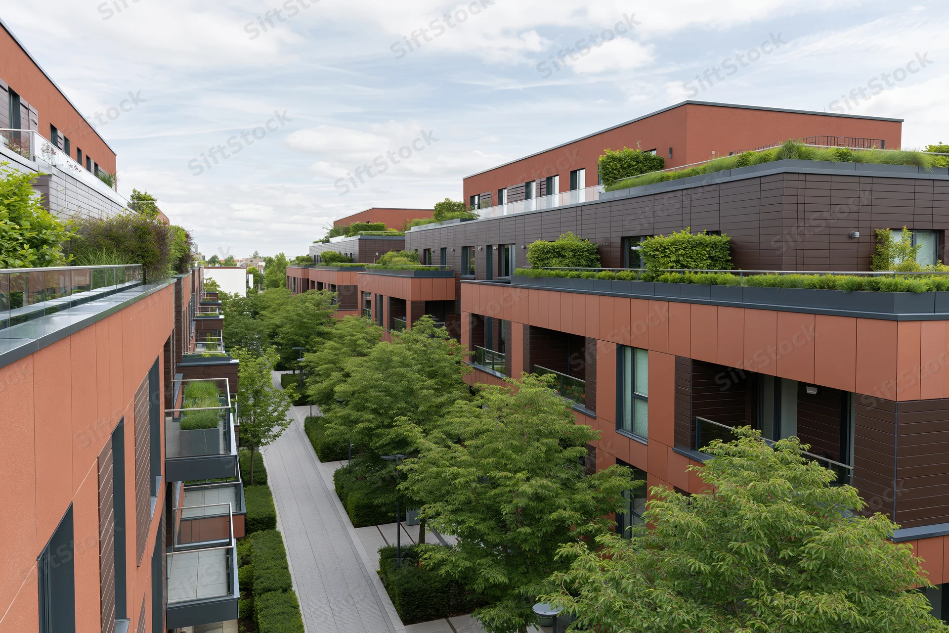 Modern residential apartment complex with rooftop gardens and greenery along a central walkway