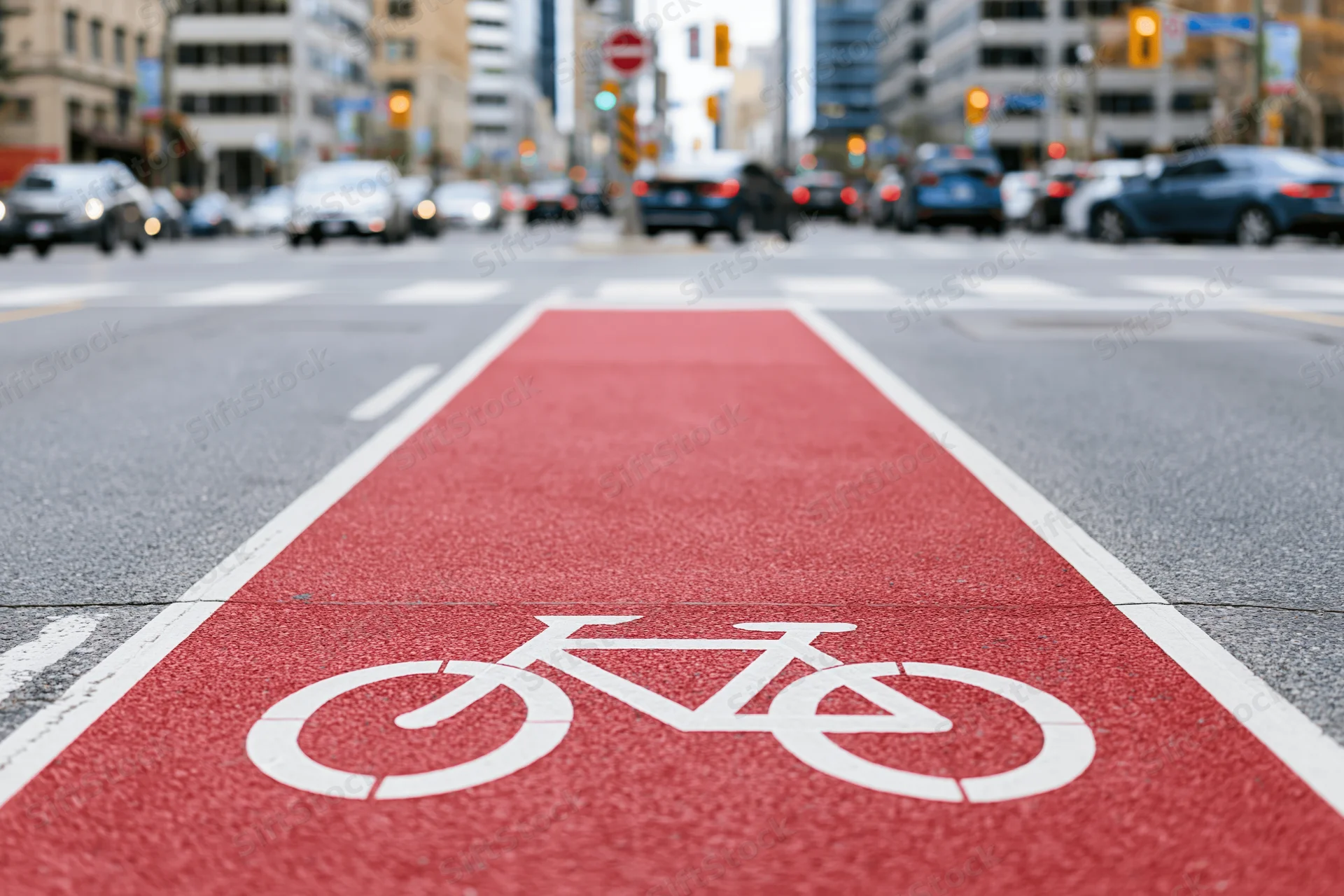Red-painted bicycle lane with white cyclist symbol on urban street pavement