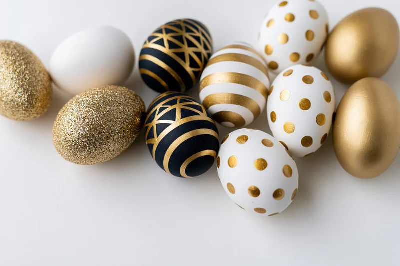 Decorated easter eggs arranged diagonally on white background with copyspace