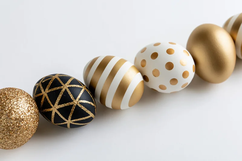 Seven decorated easter eggs arranged diagonally in a row on a white surface