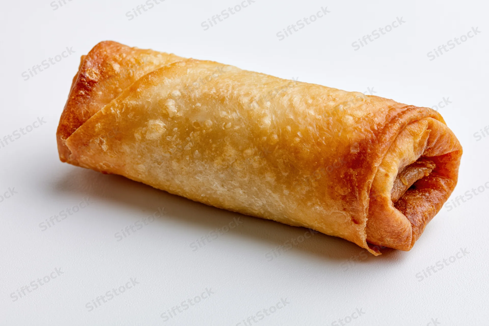 Single fried egg roll resting on a clean white surface with copyspace