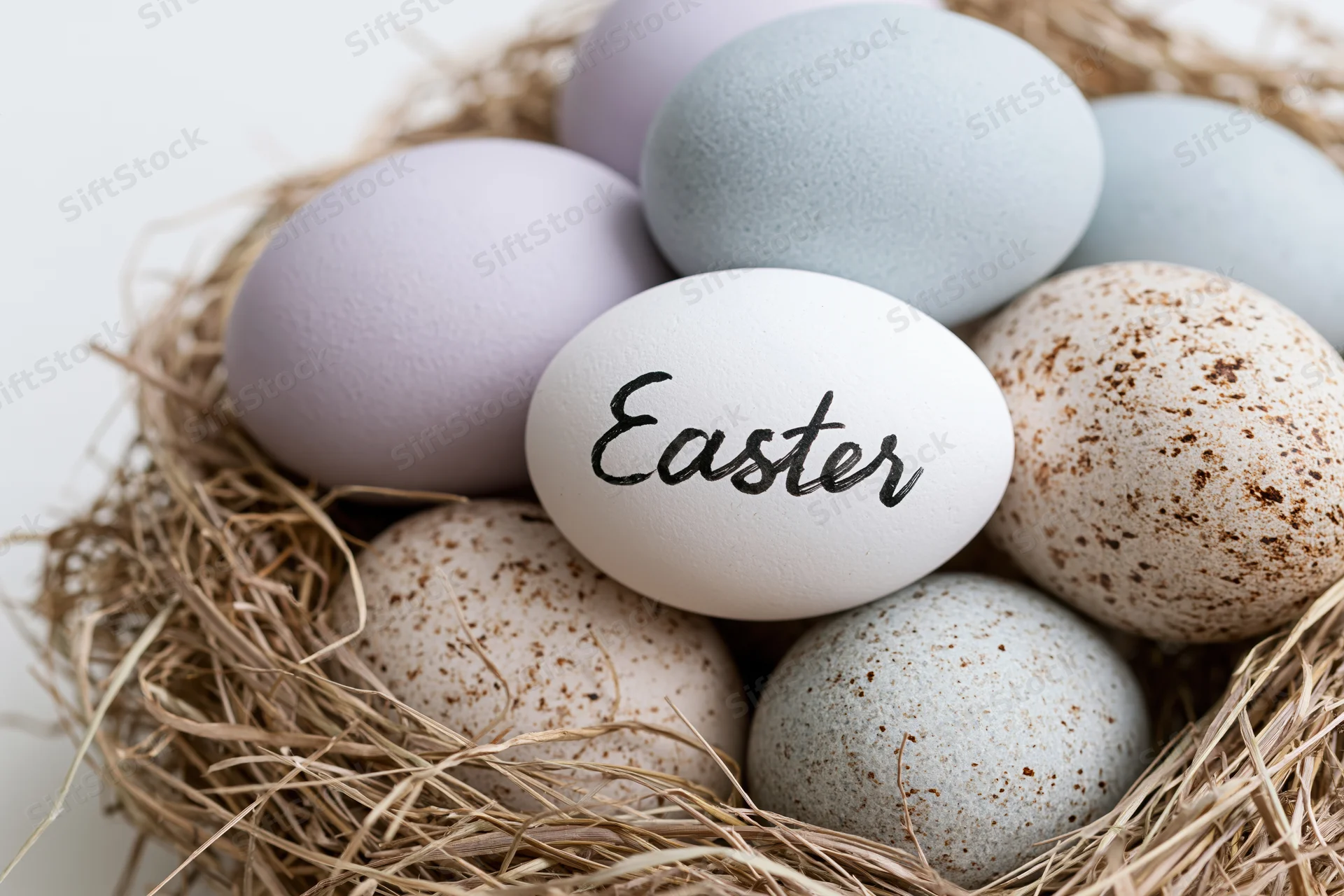 Easter eggs in a straw nest with one labeled "Easter" in black script