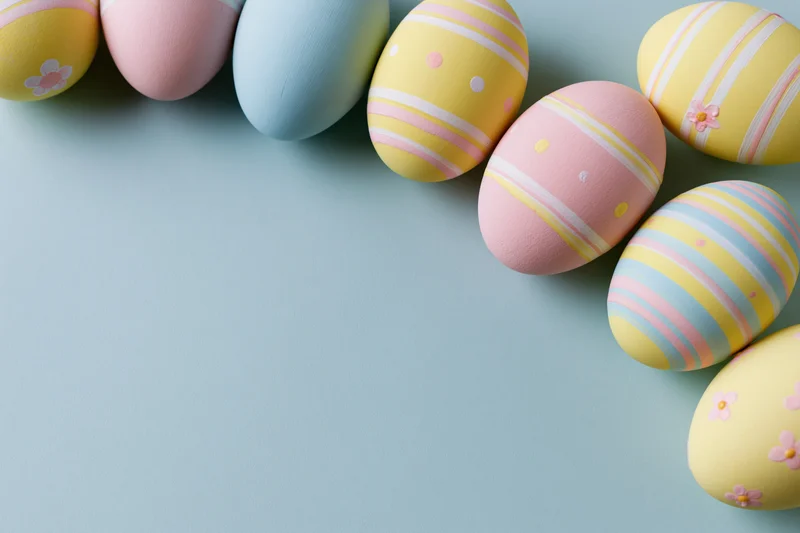 Decorated easter eggs arranged along the top and right edge on a pastel blue background