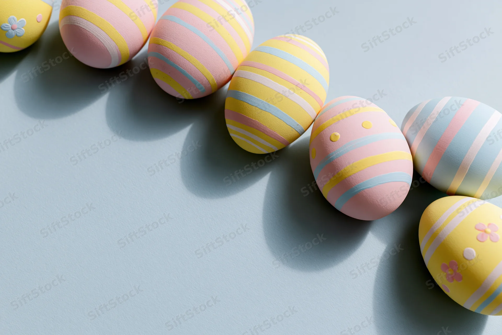 Decorated easter eggs arranged diagonally along the top and right edge on a light blue surface